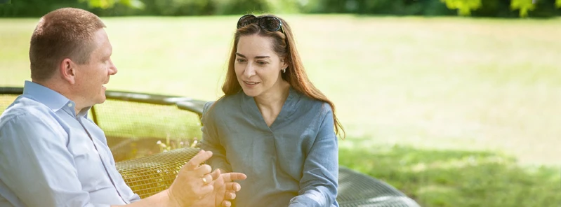 Zwei Personen im Gespr&auml;ch im Freien.